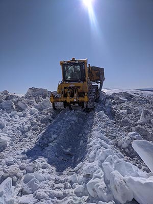 click for larger view of photo: A dozer clears snow from American Summit in April.