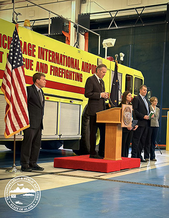 Governor Dunleavy at podium during press event at Anchorage International Airport