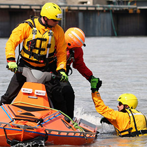 two rescuers on a jet ski provide assistance to someone in the water