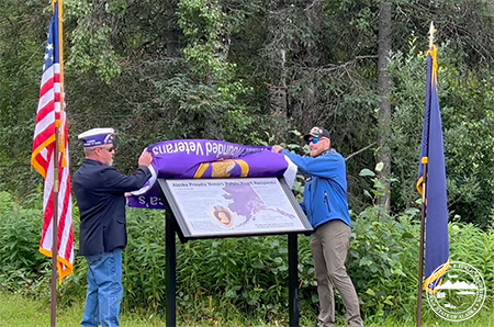 Former Alaska Commander of the Military Order of the Purple Heart John Knott and former Alaska State Senator Josh Revak unveil a new Purple Heart Trail information kiosk at the Veteran’s Memorial on the Parks Highway