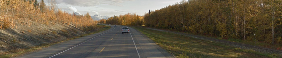 Bird's eye view of Glenn Highway with trees on the right side and the Matanuska River on the left