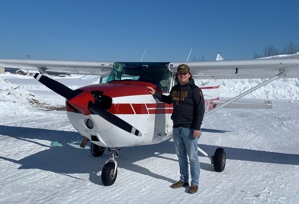 Jake Golden stands in front of a small plane