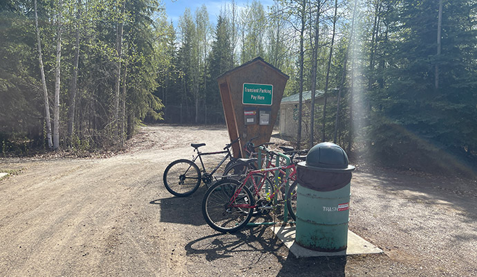 Photo of the bicycle rack, trash can, and pay station at the airpark, the long term parking area with facilities at Fairbanks International Airport