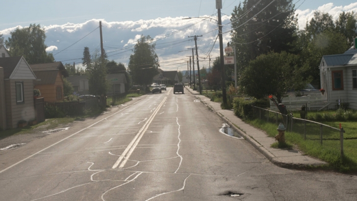 Photo showing existing conditions – drainage issues, overhead utilities, sidewalk only on the north side of the roadway