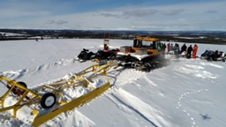 snowmachine trail grooming on gentle rolling hills