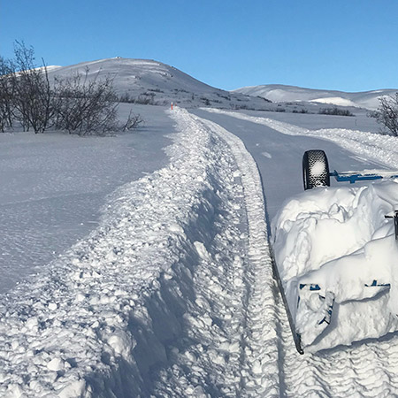 snowmachine trail grooming on gentle rolling hills