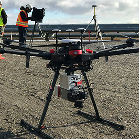 image shoing workers at a construction project with a large drone and GPS